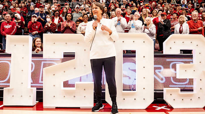 Stanford head coach Tara VanDerveer stands in front of the numbers 1203 to celebrate her become the all-time winningest coach in college basketball.